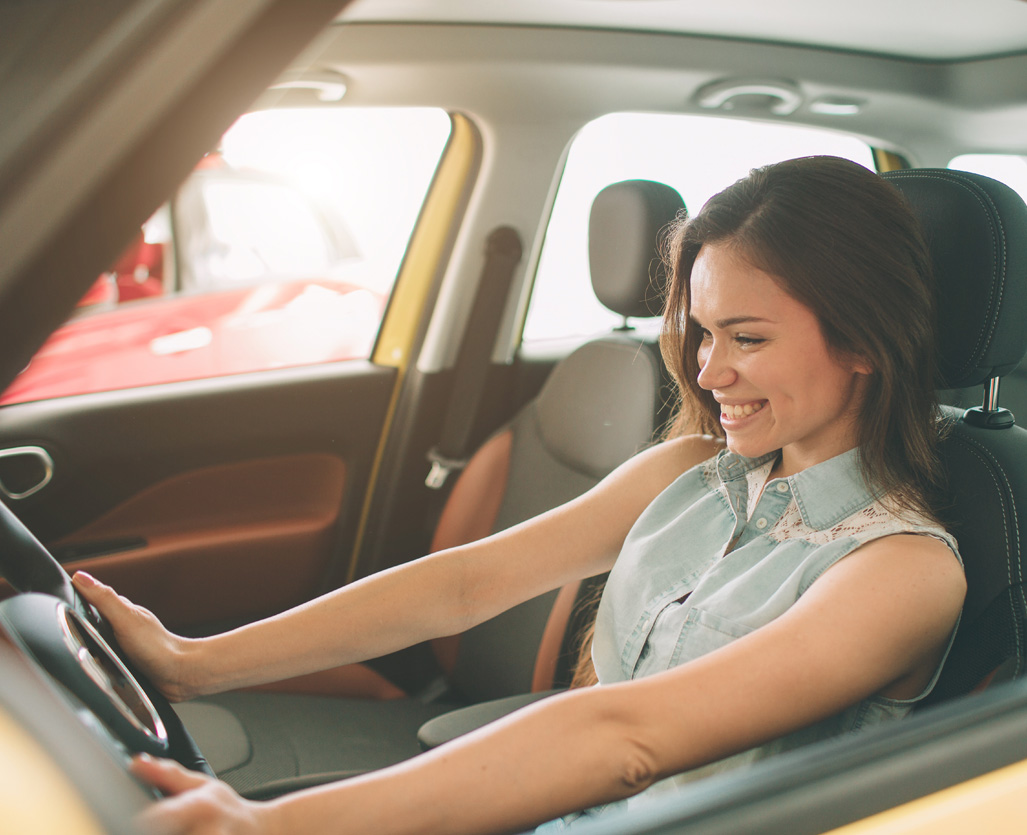 Woman happily testing out her new car