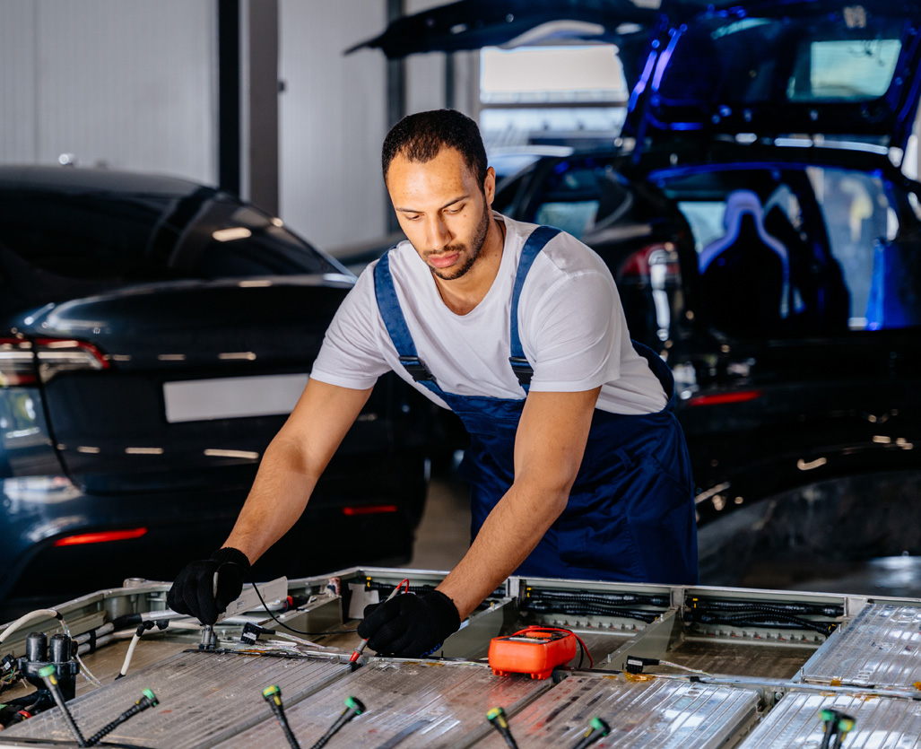 Tehnican working on an EV battery in a workshop